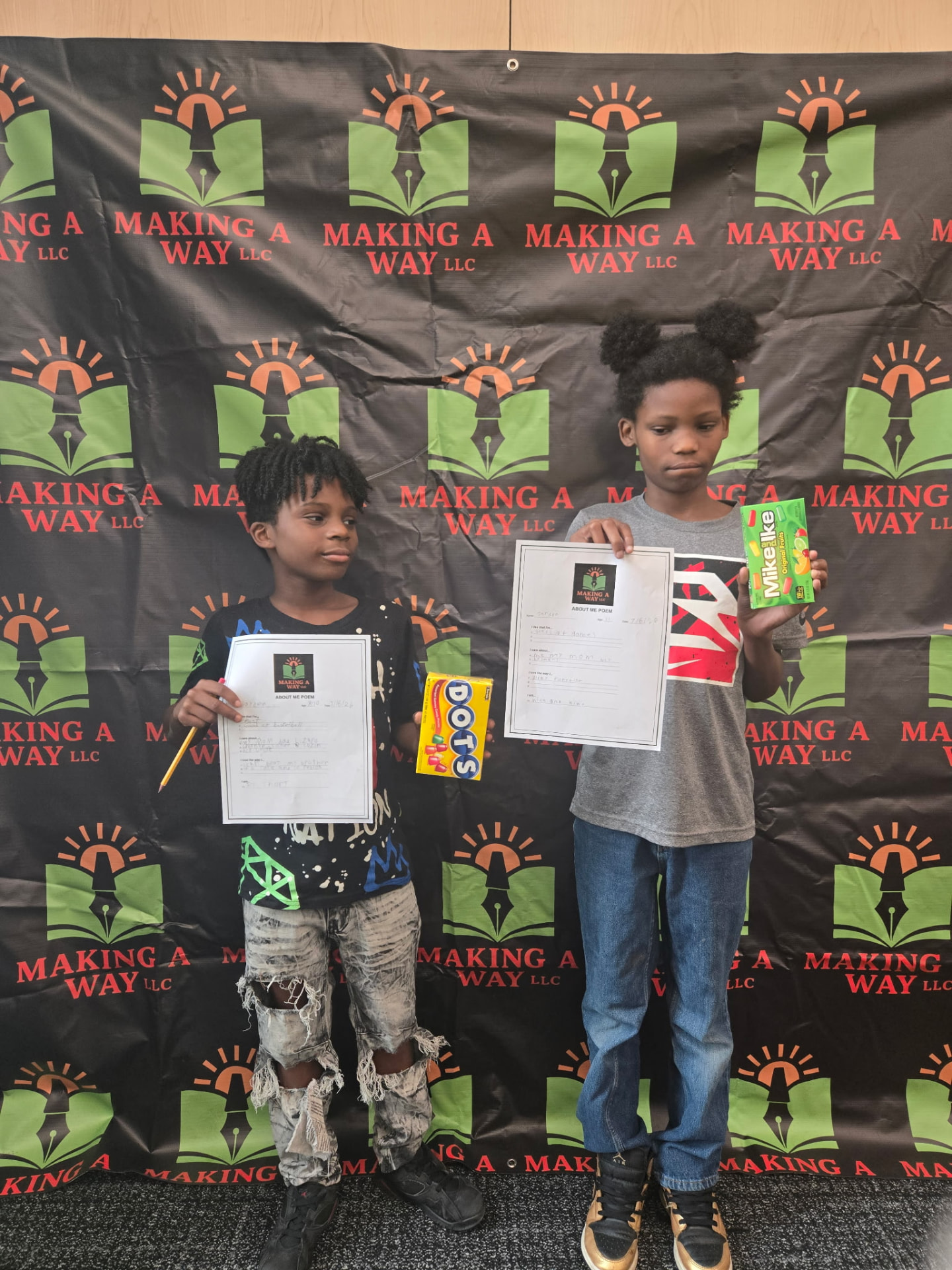 Two young poets holding their poems at a Making A Way event