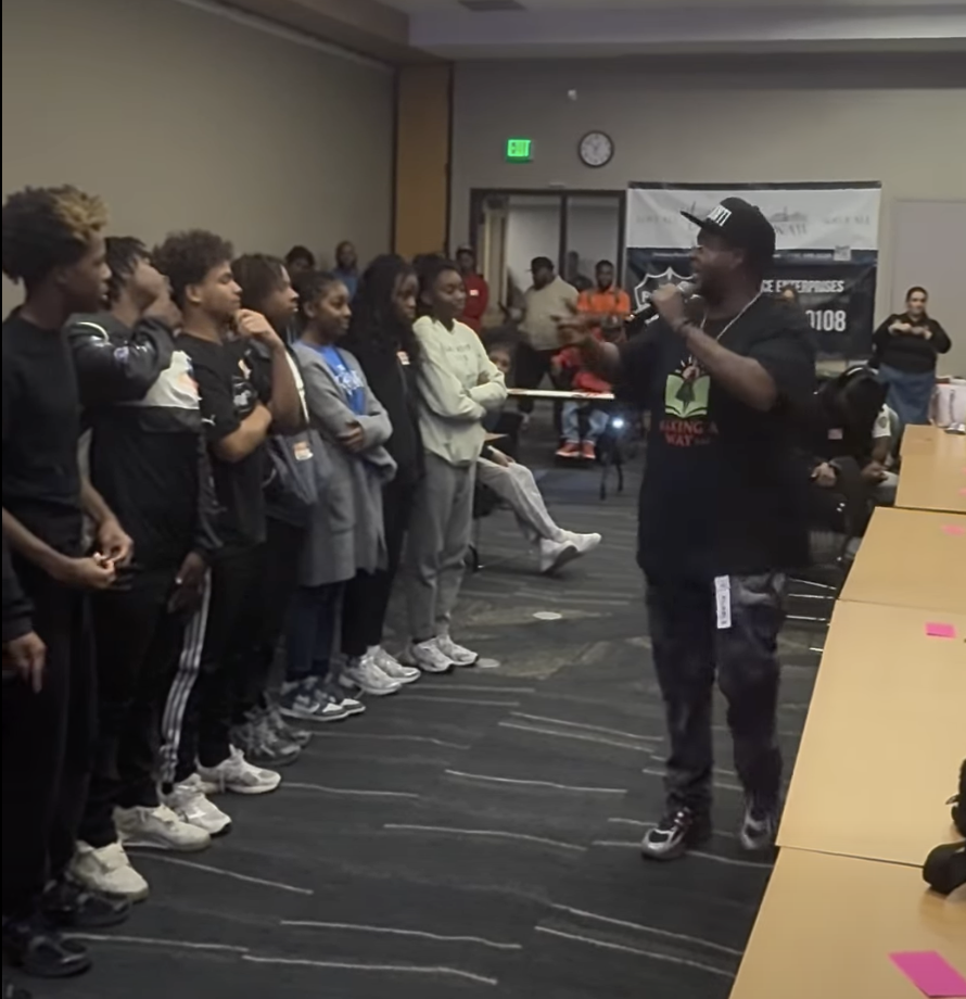 Speaker engaging a group of youth at an education workshop